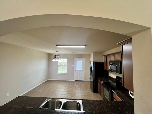484 Harding Ln, Lavon, TX 75166 - kitchen featuring black appliances, dark countertops, light tile patterned floors, a chandelier, and pendant lighting