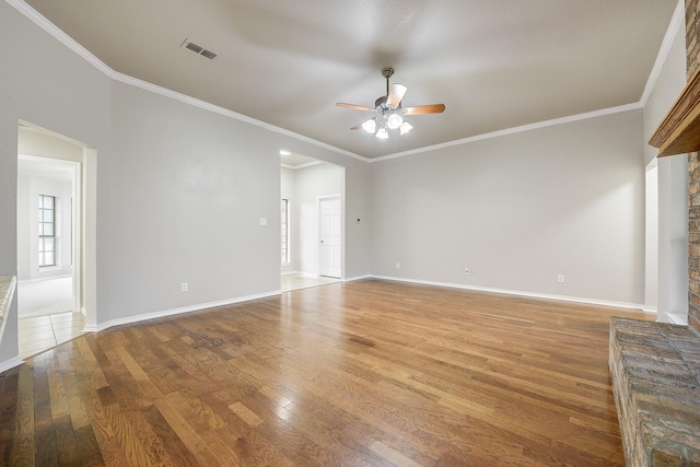 11440 Mitchell Cir, Ponder, TX 76259 - spare room featuring ceiling fan, wood finished floors, crown molding, and a brick fireplace