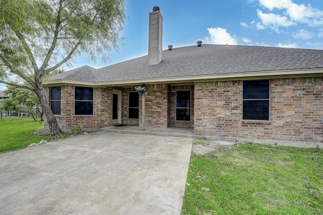 11440 Mitchell Cir, Ponder, TX 76259 - back of property with a chimney, a shingled roof, a lawn, and a patio area