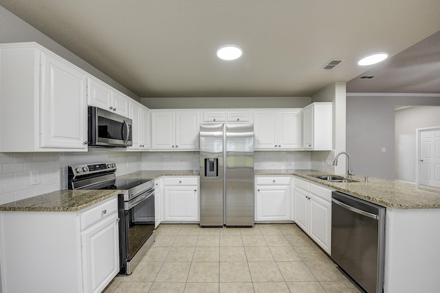 11440 Mitchell Cir, Ponder, TX 76259 - kitchen featuring appliances with stainless steel finishes, decorative backsplash, a peninsula, white cabinetry, and ornamental molding