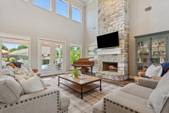400 Wycliff Dr, China Spring, TX 76633 - living room with a high ceiling, light wood-style floors, french doors, a fireplace, and crown molding