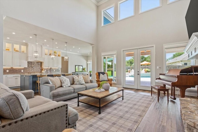 400 Wycliff Dr, China Spring, TX 76633 - living area featuring crown molding, light wood-style flooring, a high ceiling, french doors, and a chandelier