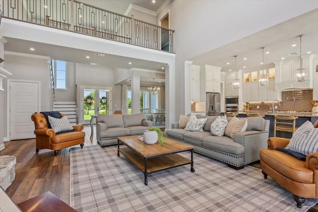 400 Wycliff Dr, China Spring, TX 76633 - living area featuring a chandelier, a high ceiling, stairs, light wood-style floors, and ornamental molding