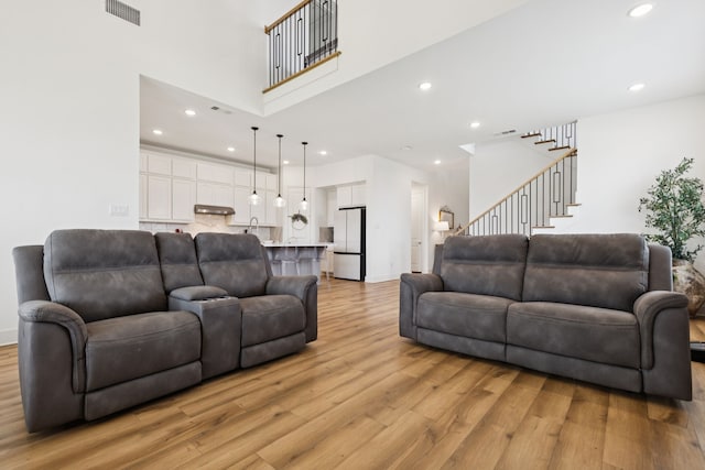 1814 Cypress Gap Trl, Mansfield, TX 76063 - living area featuring light wood finished floors, a towering ceiling, recessed lighting, and stairway