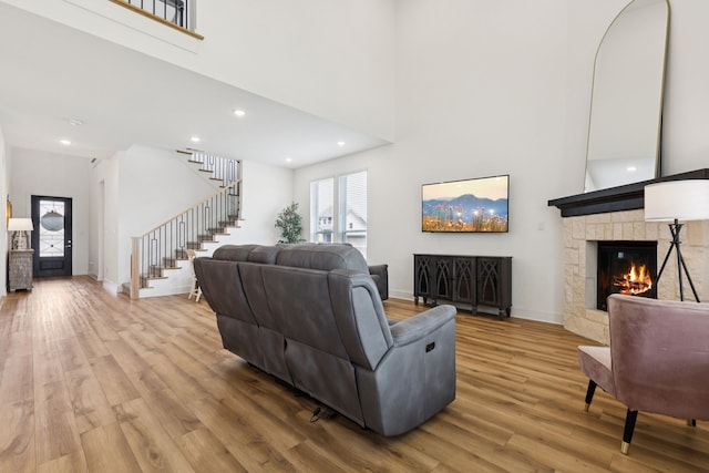 1814 Cypress Gap Trl, Mansfield, TX 76063 - living room featuring wood finished floors, a stone fireplace, stairs, a towering ceiling, and recessed lighting