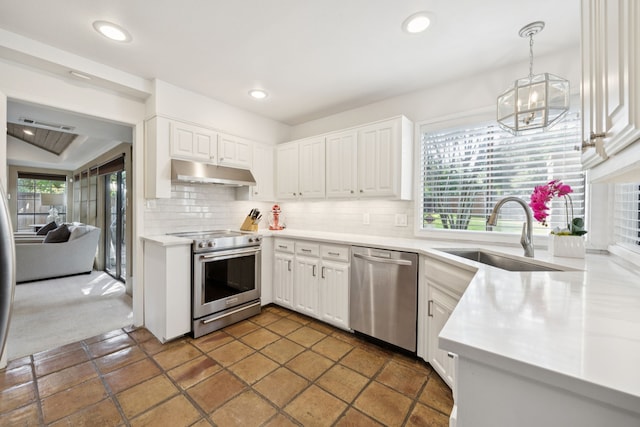 6250 Twin Oaks Cir, Dallas, TX 75240 - kitchen featuring appliances with stainless steel finishes, under cabinet range hood, tasteful backsplash, a chandelier, and white cabinetry