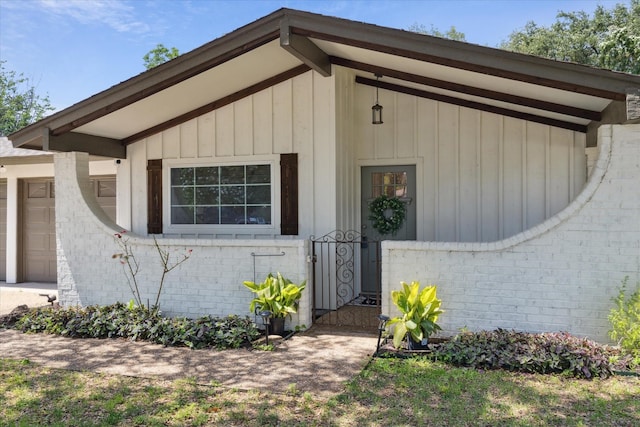 4632 Ivanhoe Dr, Fort Worth, TX 76132 - view of exterior entry with brick siding, board and batten siding, and an attached garage