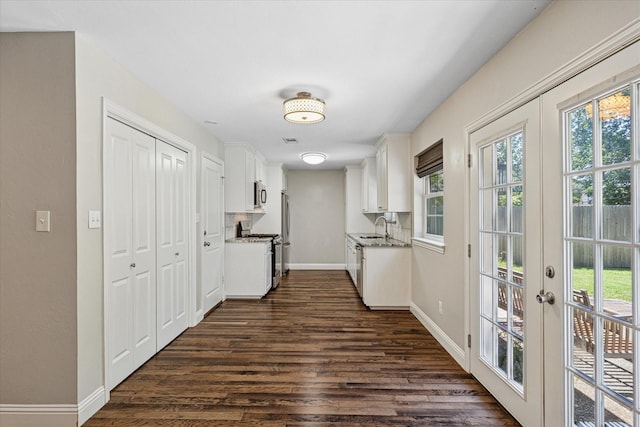 4632 Ivanhoe Dr, Fort Worth, TX 76132 - kitchen with appliances with stainless steel finishes, dark wood-style flooring, white cabinets, and french doors