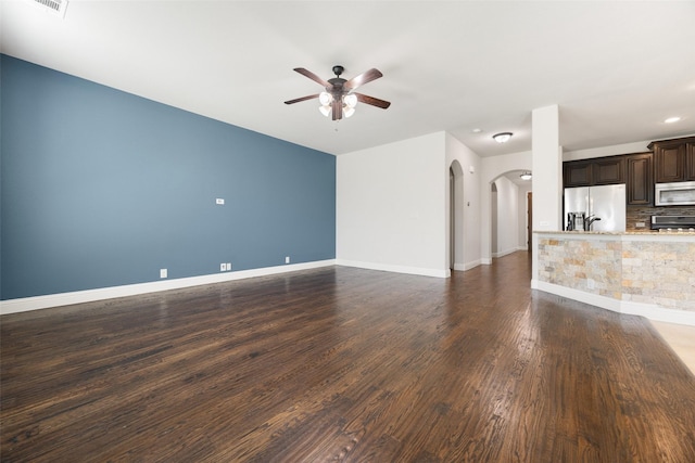1020 Perennial Ln, Little Elm, TX 75068 - unfurnished living room featuring arched walkways, ceiling fan, and dark wood-type flooring