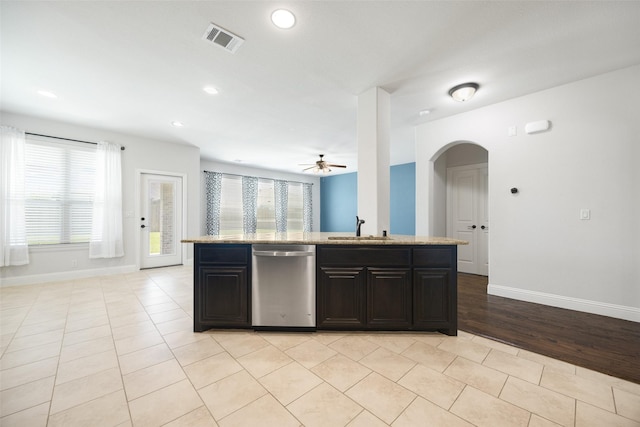 1020 Perennial Ln, Little Elm, TX 75068 - kitchen featuring dishwasher, ceiling fan, arched walkways, light stone counters, and an island with sink