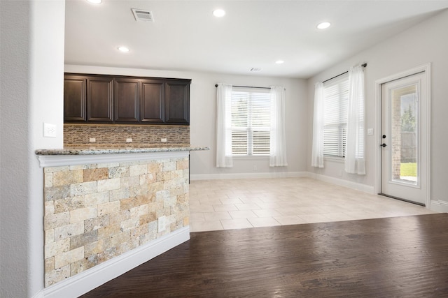 1020 Perennial Ln, Little Elm, TX 75068 - kitchen featuring dark brown cabinetry, recessed lighting, backsplash, light stone counters, and light tile patterned floors