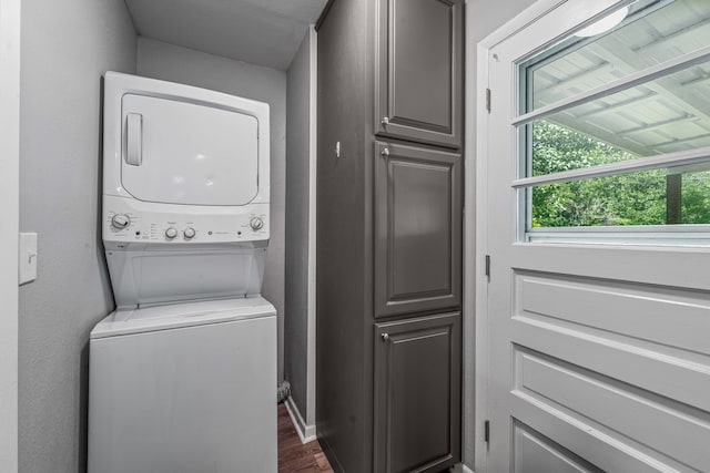 1007 College Ave, Glen Rose, TX 76043 - washroom with stacked washer and clothes dryer, cabinet space, and dark wood-style flooring