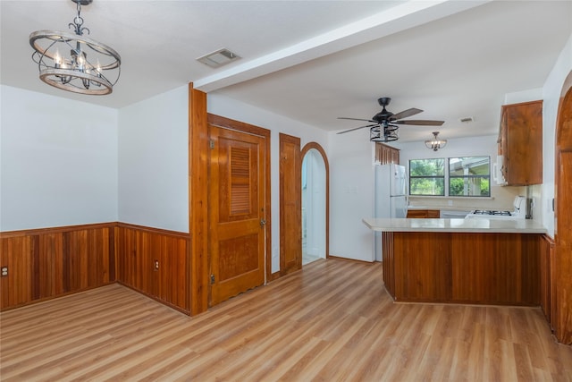 4525 Midway Rd, Weatherford, TX 76085 - kitchen featuring a chandelier, light wood-style floors, brown cabinetry, light countertops, and a wainscoted wall