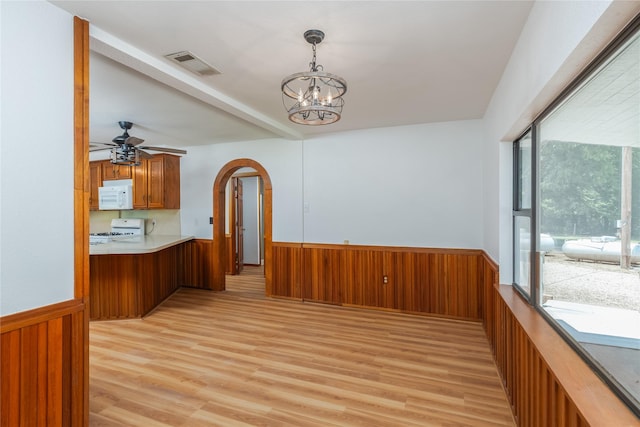 4525 Midway Rd, Weatherford, TX 76085 - unfurnished dining area featuring wainscoting, light wood-type flooring, a chandelier, arched walkways, and wooden walls