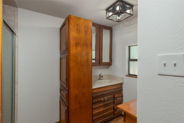 4525 Midway Rd, Weatherford, TX 76085 - full bath with vanity, a textured wall, and an enclosed shower