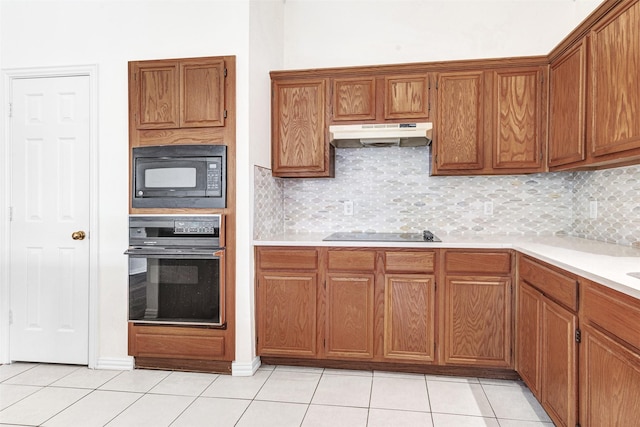 2400 Havard Oak Dr, Plano, TX 75074 - kitchen with black appliances, under cabinet range hood, light tile patterned flooring, brown cabinets, and light countertops