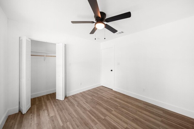 1214 Cove Dr, Garland, TX 75040 - unfurnished bedroom featuring wood finished floors, a closet, and a ceiling fan