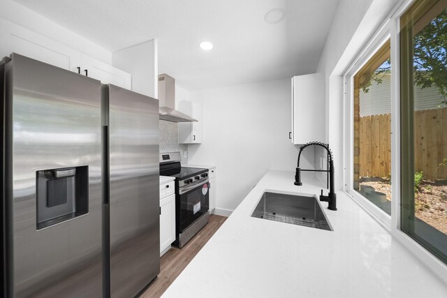 1214 Cove Dr, Garland, TX 75040 - kitchen with appliances with stainless steel finishes, wall chimney exhaust hood, backsplash, white cabinetry, and recessed lighting