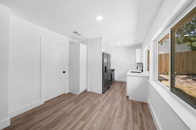 1214 Cove Dr, Garland, TX 75040 - kitchen featuring stainless steel fridge, plenty of natural light, light wood-style floors, light countertops, and recessed lighting