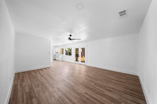 1214 Cove Dr, Garland, TX 75040 - unfurnished living room with a ceiling fan, wood finished floors, and french doors