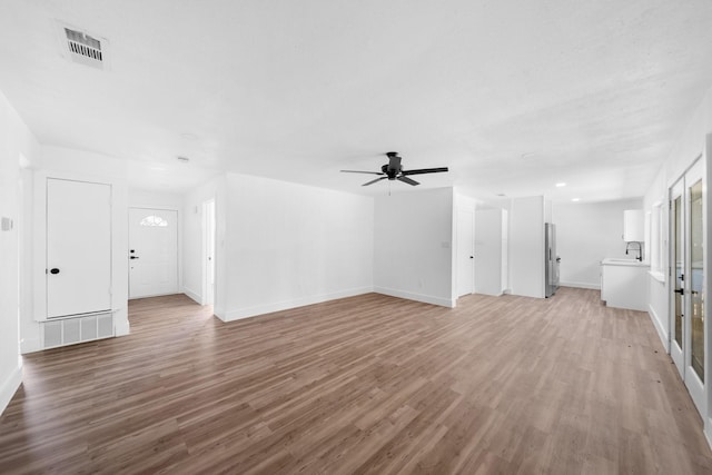 1214 Cove Dr, Garland, TX 75040 - unfurnished living room featuring a ceiling fan and light wood-style flooring