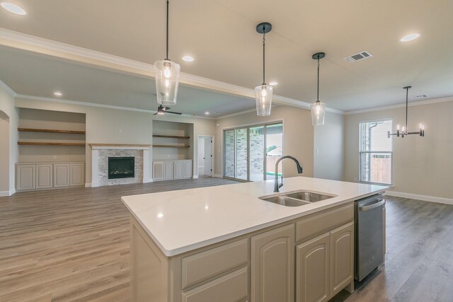 213 Navajo Trl, Alvarado, TX 76009 - kitchen featuring light wood-type flooring, healthy amount of natural light, light countertops, crown molding, and an island with sink
