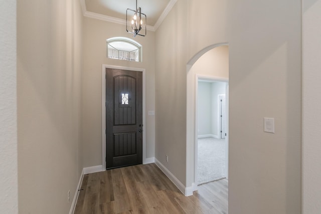 213 Navajo Trl, Alvarado, TX 76009 - entrance foyer featuring arched walkways, crown molding, wood finished floors, a towering ceiling, and a chandelier