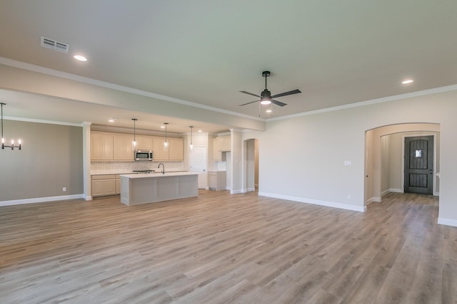 213 Navajo Trl, Alvarado, TX 76009 - kitchen featuring arched walkways, stainless steel microwave, open floor plan, ceiling fan, and recessed lighting