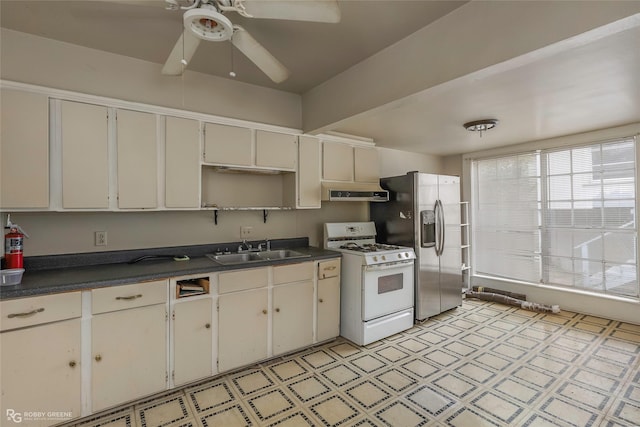 538 Dalzell St, Shreveport, LA 71104 - kitchen featuring gas range gas stove, under cabinet range hood, dark countertops, light floors, and ceiling fan