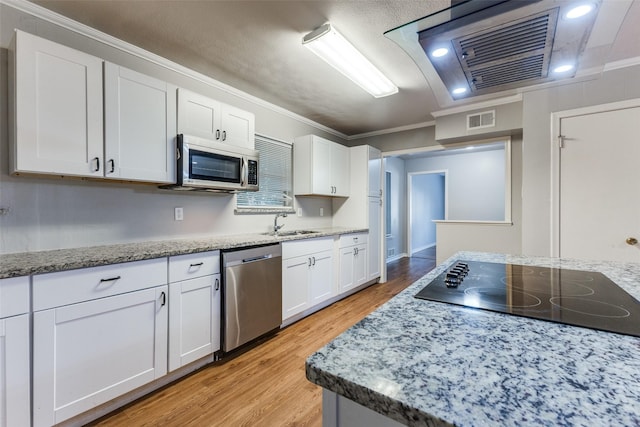 3209 Pecan Ln, Garland, TX 75041 - kitchen with stainless steel appliances, white cabinets, light wood finished floors, crown molding, and light stone counters