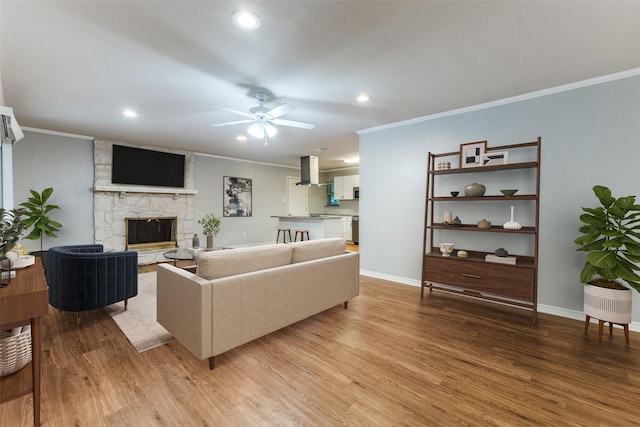 3209 Pecan Ln, Garland, TX 75041 - living room featuring crown molding, light wood-style floors, a stone fireplace, ceiling fan, and recessed lighting