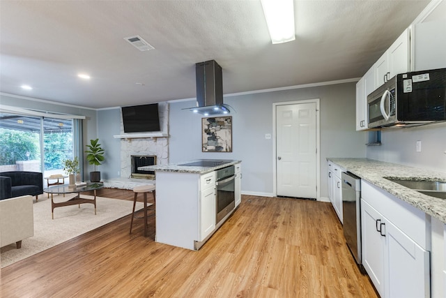 3209 Pecan Ln, Garland, TX 75041 - kitchen with stainless steel appliances, island range hood, open floor plan, crown molding, and a stone fireplace