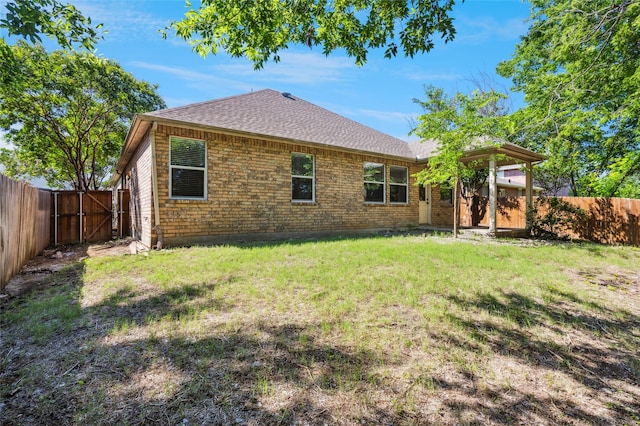 2409 Spruce Ct, Little Elm, TX 75068 - back of property featuring a shingled roof, a fenced backyard, and a gate
