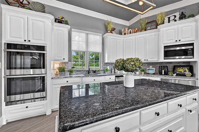 107 Bob Jones Ct, Pottsboro, TX 75076 - kitchen with appliances with stainless steel finishes, tasteful backsplash, white cabinets, light wood-style flooring, and crown molding