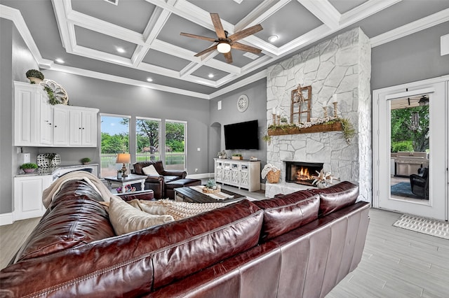 107 Bob Jones Ct, Pottsboro, TX 75076 - living area with a ceiling fan, a stone fireplace, light wood-style floors, beam ceiling, and a high ceiling