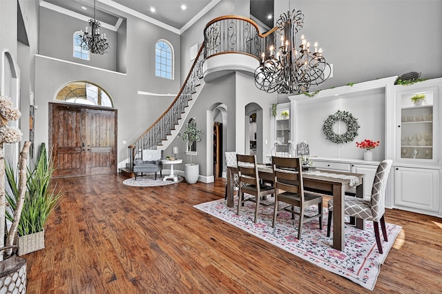 107 Bob Jones Ct, Pottsboro, TX 75076 - dining room featuring a chandelier, arched walkways, ornamental molding, a high ceiling, and wood finished floors