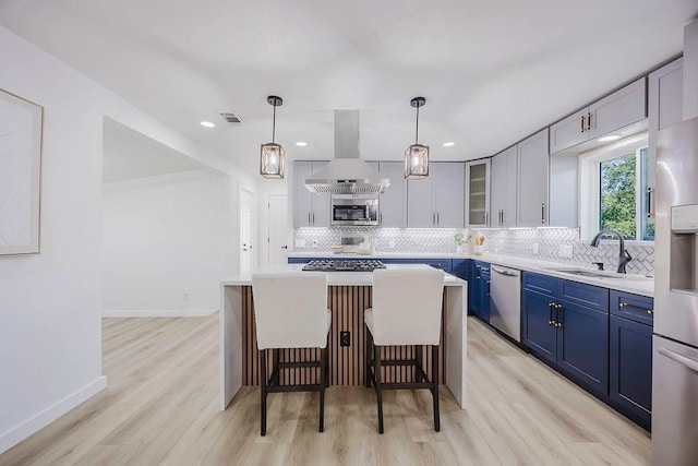 2504 Guilford Rd, Fort Worth, TX 76107 - kitchen featuring extractor fan, blue cabinetry, stainless steel appliances, a kitchen breakfast bar, and light wood finished floors