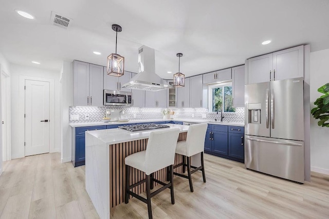2504 Guilford Rd, Fort Worth, TX 76107 - kitchen with appliances with stainless steel finishes, blue cabinets, island exhaust hood, decorative backsplash, and recessed lighting