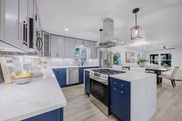 2504 Guilford Rd, Fort Worth, TX 76107 - kitchen with stainless steel appliances, blue cabinets, island range hood, backsplash, and ceiling fan
