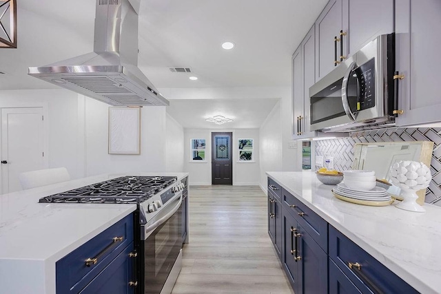 2504 Guilford Rd, Fort Worth, TX 76107 - kitchen with island range hood, stainless steel appliances, blue cabinetry, light wood-type flooring, and recessed lighting