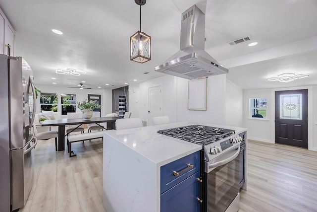 2504 Guilford Rd, Fort Worth, TX 76107 - kitchen with appliances with stainless steel finishes, island exhaust hood, blue cabinetry, light wood-style flooring, and light countertops