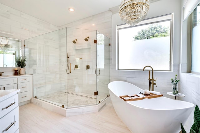 800 Manor Dr, Argyle, TX 76226 - bathroom featuring vanity, tile walls, a freestanding tub, a stall shower, and a chandelier