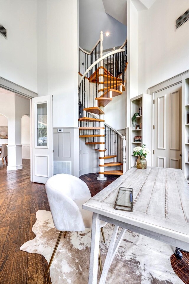 800 Manor Dr, Argyle, TX 76226 - stairs with a towering ceiling, arched walkways, a decorative wall, wood finished floors, and wainscoting