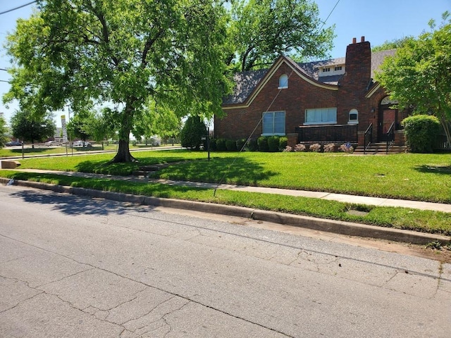 2848 Forest Ave, Fort Worth, TX 76112 - view of front of home featuring a front lawn, a chimney, and brick siding