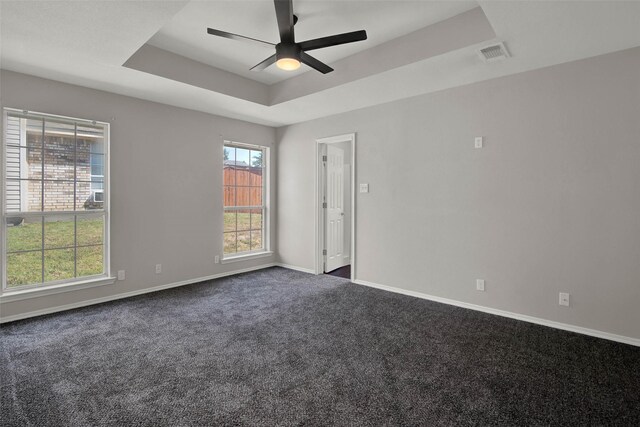 4909 Indio Ln, Sherman, TX 75092 - empty room featuring a raised ceiling, a ceiling fan, and dark carpet