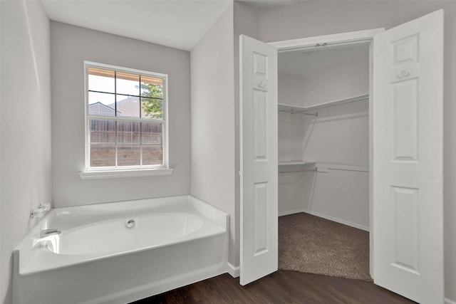 4909 Indio Ln, Sherman, TX 75092 - bathroom with a bath, wood finished floors, and a walk in closet