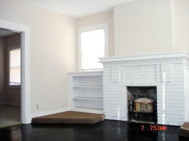 111 N Winnetka Ave, Dallas, TX 75208 - unfurnished living room with wood finished floors, plenty of natural light, and a brick fireplace