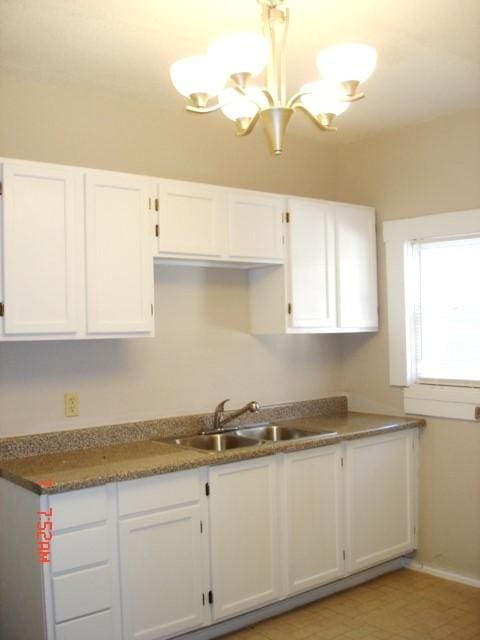 111 N Winnetka Ave, Dallas, TX 75208 - kitchen with a chandelier and white cabinetry