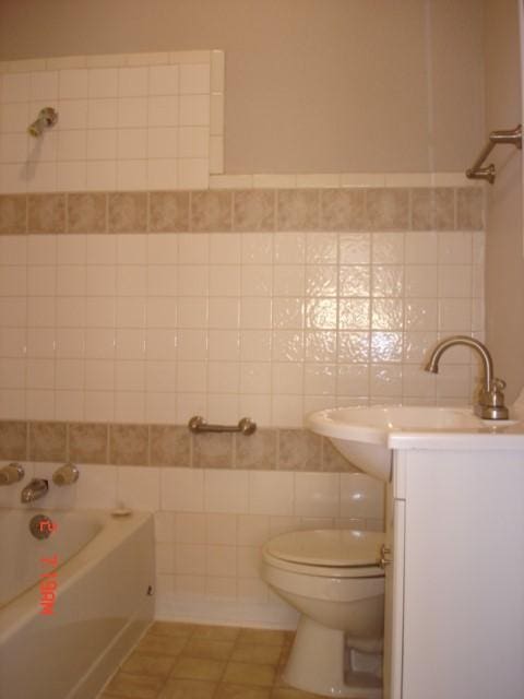 111 N Winnetka Ave, Dallas, TX 75208 - bathroom featuring a tub, vanity, tile walls, and tile patterned floors