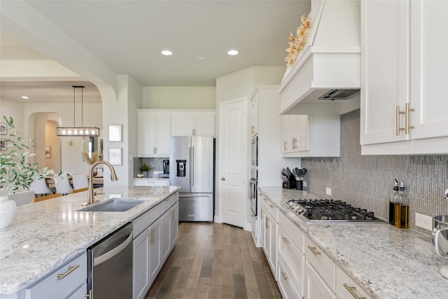 1253 Gray Fox Ln, Frisco, TX 75033 - kitchen featuring appliances with stainless steel finishes, premium range hood, white cabinets, pendant lighting, and light stone counters